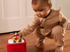 Child playing with a red toniebox 2 and Disney Mickey Mouse Clubhouse Tonie